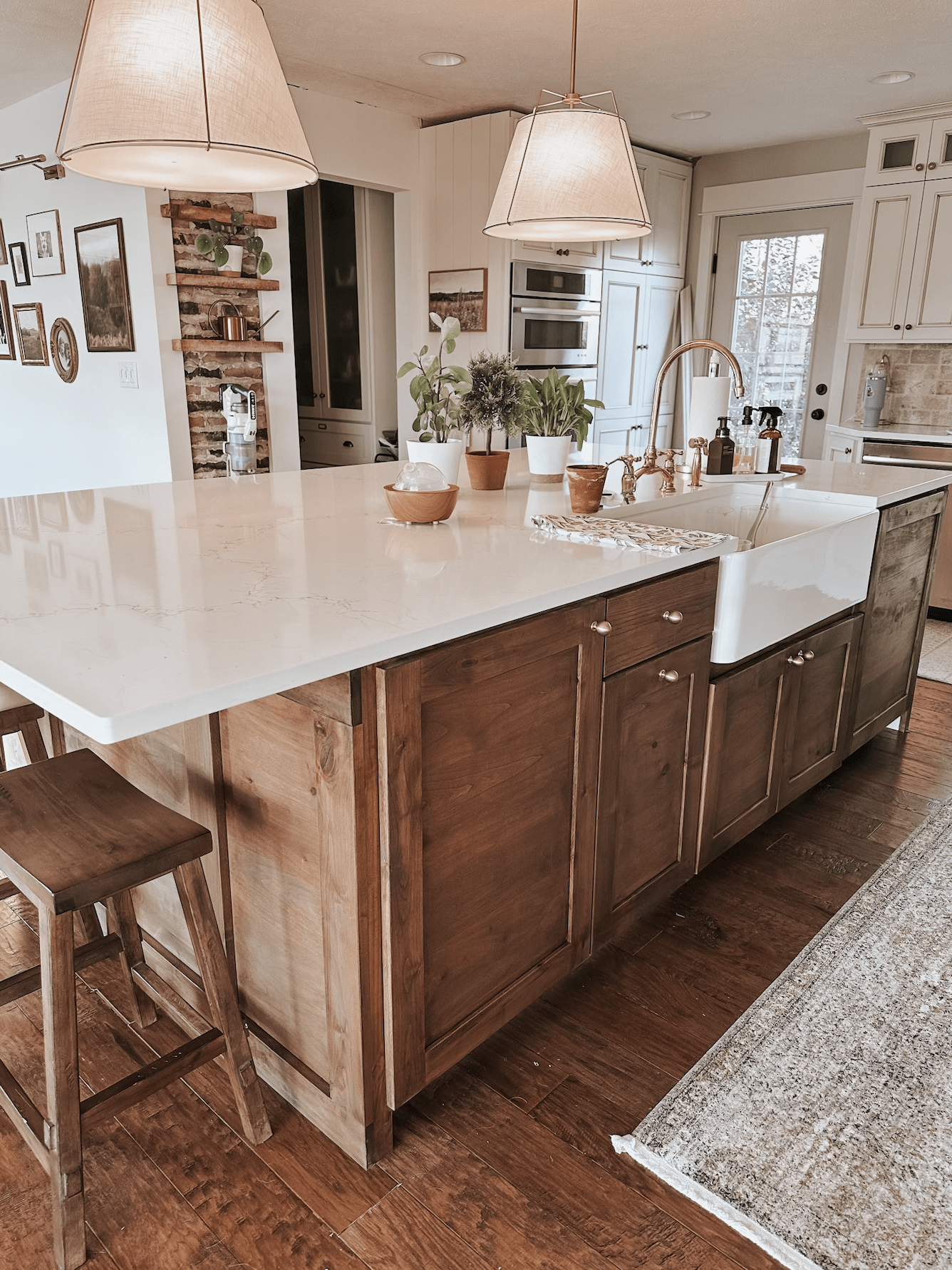 Beautiful farmhouse style kitchen island with seating, farmhouse style sink, antique brass faucet.